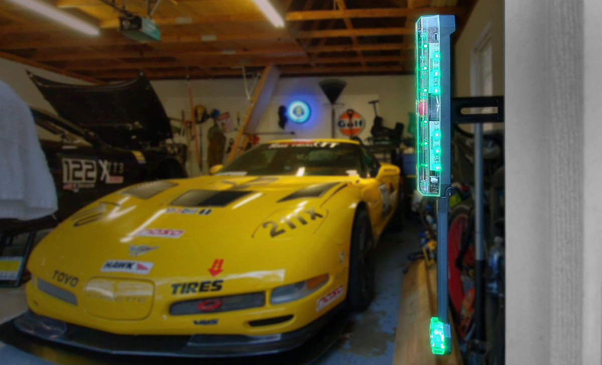 close up of an STKR Side Garage Sensor with a Corvette unfocused garage scene in the background