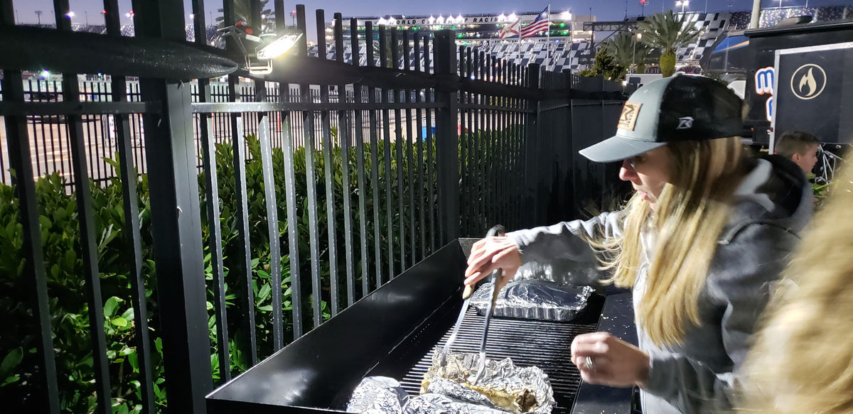 woman grilling in the pits at a major speedway lit up by a Mobile Task Light