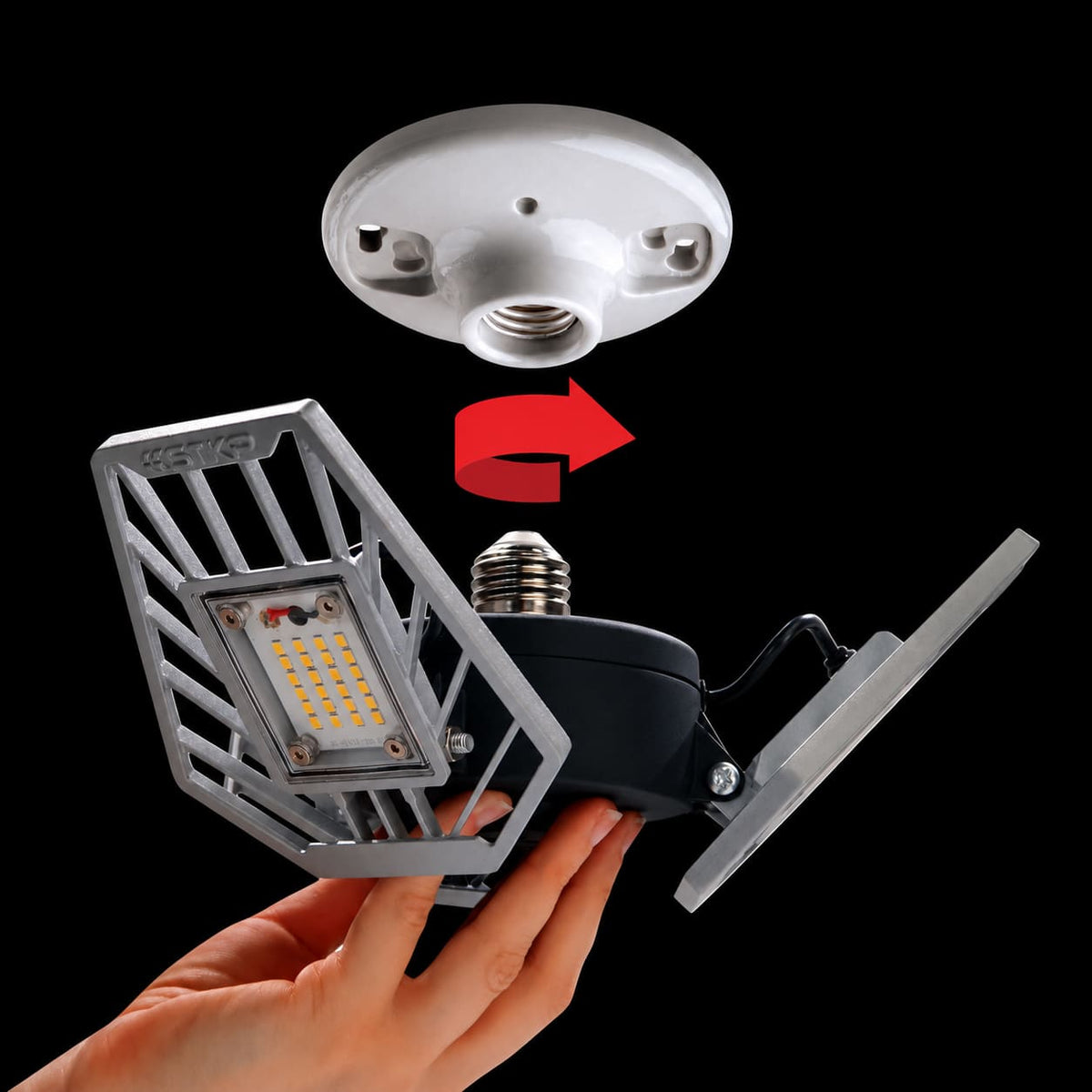 Hand holding TRiLIGHT 2.0 below a ceiling socket to show twist-in installation